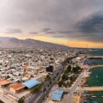 تصویر اسکله بندر کنگان با انعکاس آب پس از باران و لنج‌های پهلو گرفته در استان بوشهر