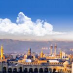 عکس هوایی حرم امام رضا (ع) و مسجد گوهرشاد با پس‌زمینه شهر مشهد و کوه‌های بینالود