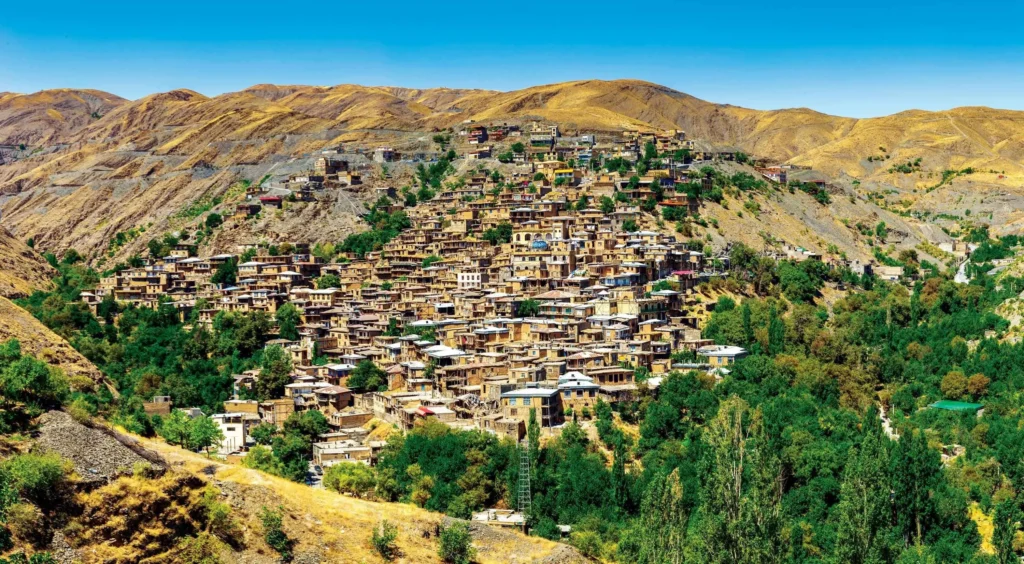 نمایی از روستای کوهستانی طرقبه مشهد با خانههای روستایی و طبیعت سرسبز کوهستان